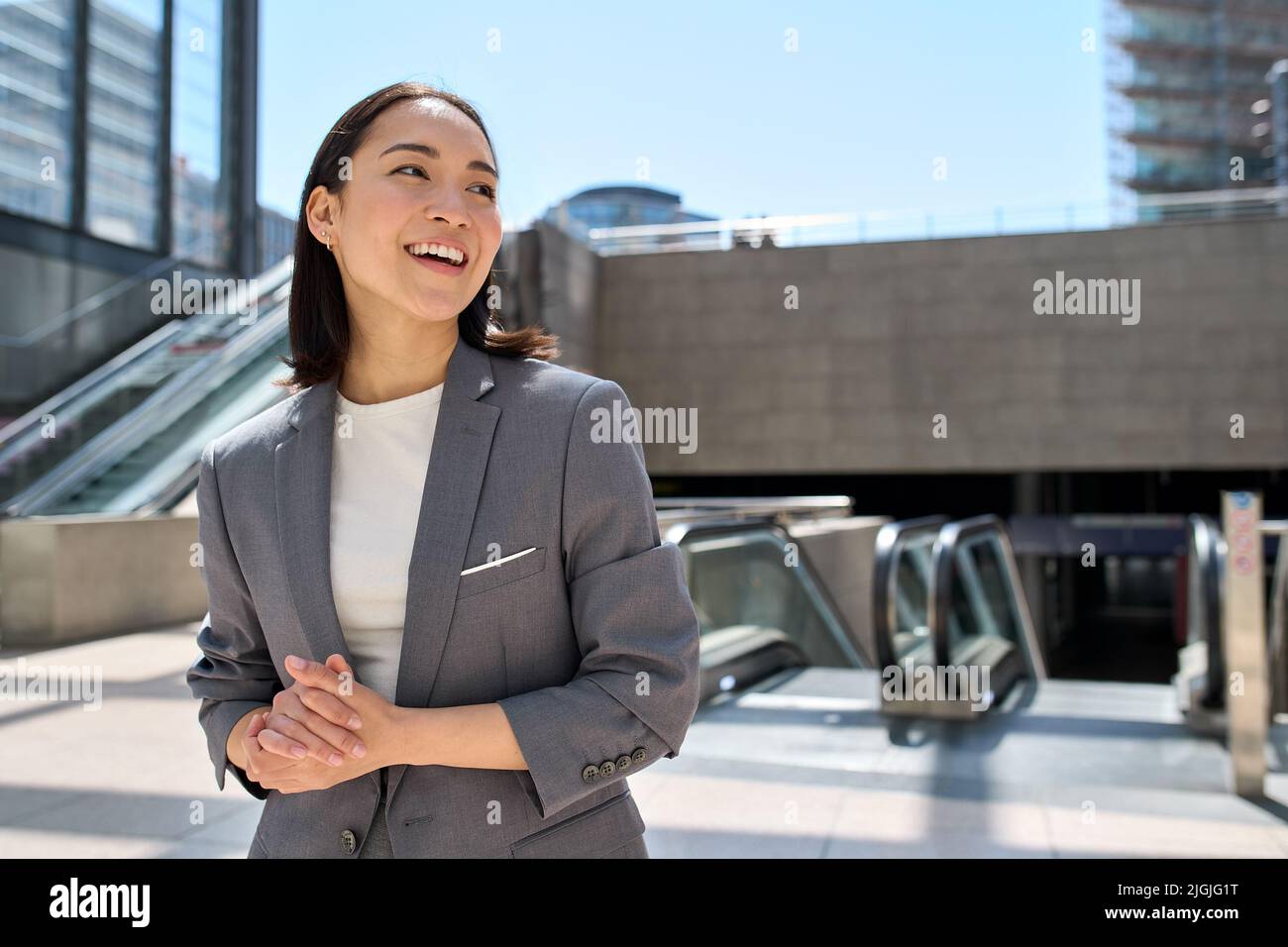 Joven empresaria asiática feliz de pie en la ciudad urbana ubicación. Foto de stock