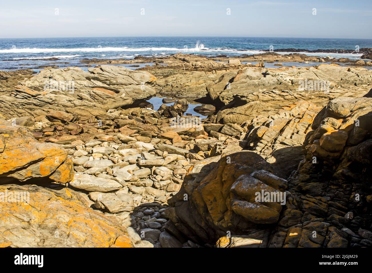 Grandes rocas esparcidas en la rocosa costa de Tsitsikamma en el Parque Nacional Garden Route, Sudáfrica Foto de stock