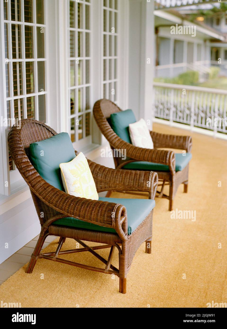 Dos sillas de mimbre en un porche envolvente en el Four Seasons Resort Lana'i, The Lodge at Koele. Lana'i, Hawai, EE.UU. Foto de stock