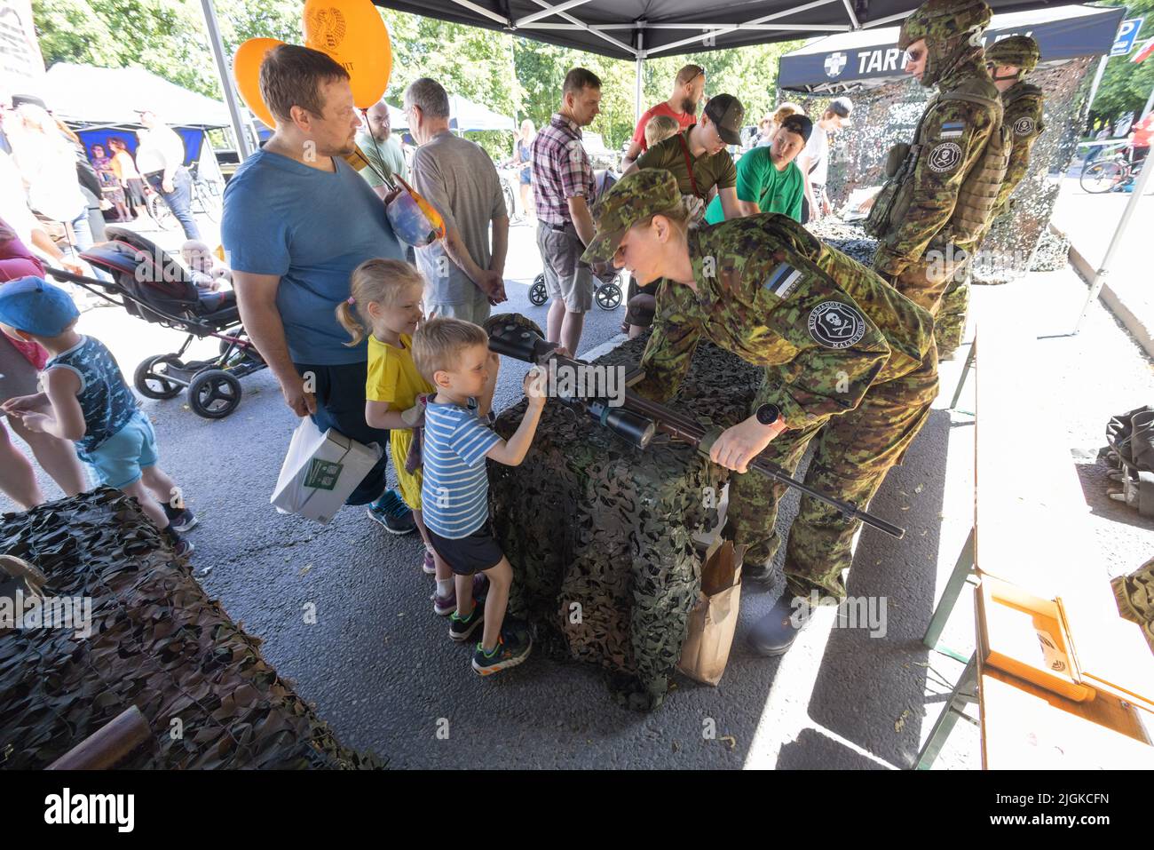 Un soldado de la Liga de Defensa de Estonia muestra armas y armas a niños pequeños el Día de la Victoria, Tartu (Estonia), los Estados Bálticos (Europa) Foto de stock
