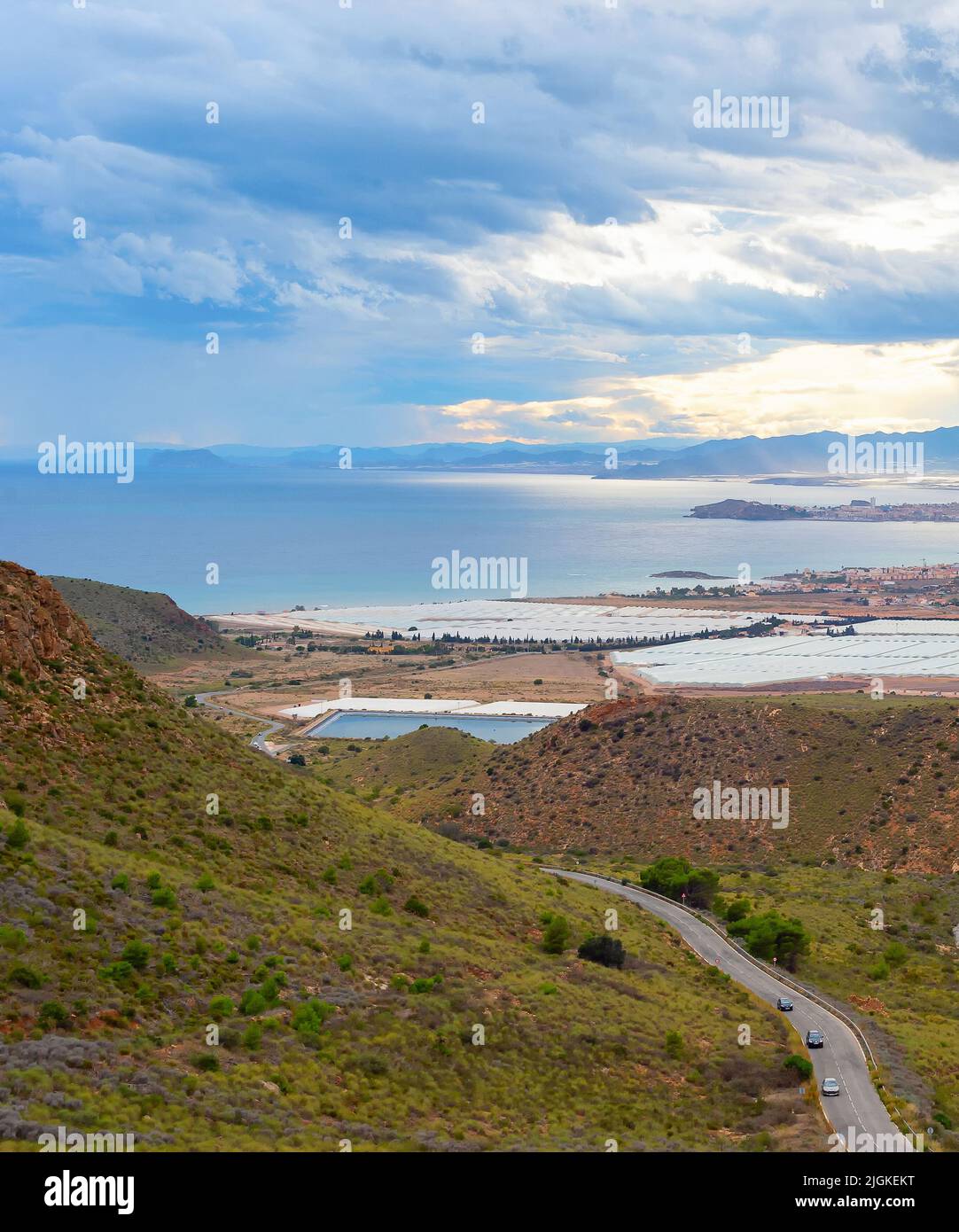Paisaje con montañas y pueblo en vista costera bajo cielo tormentoso, al sur de España Foto de stock