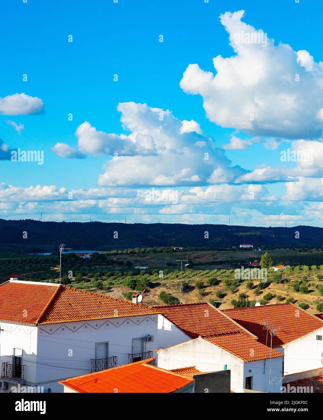 Paisaje natural con vista al pueblo y a los jardines de olivo, montañas y nubes, España Foto de stock