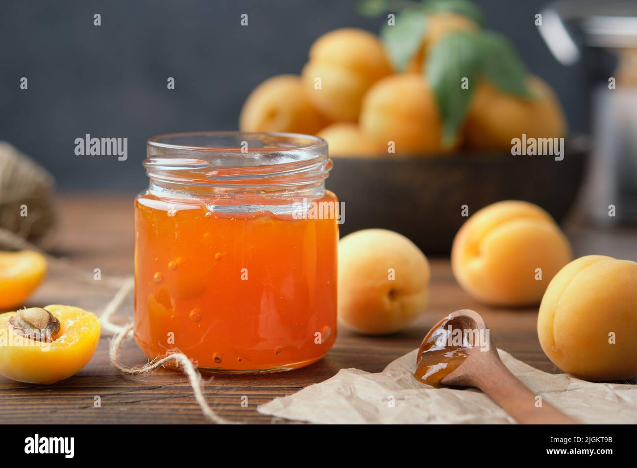 Tarro de mermelada casera de albaricoque y frutas maduras de albaricoque sobre la mesa de la cocina. Foto de stock