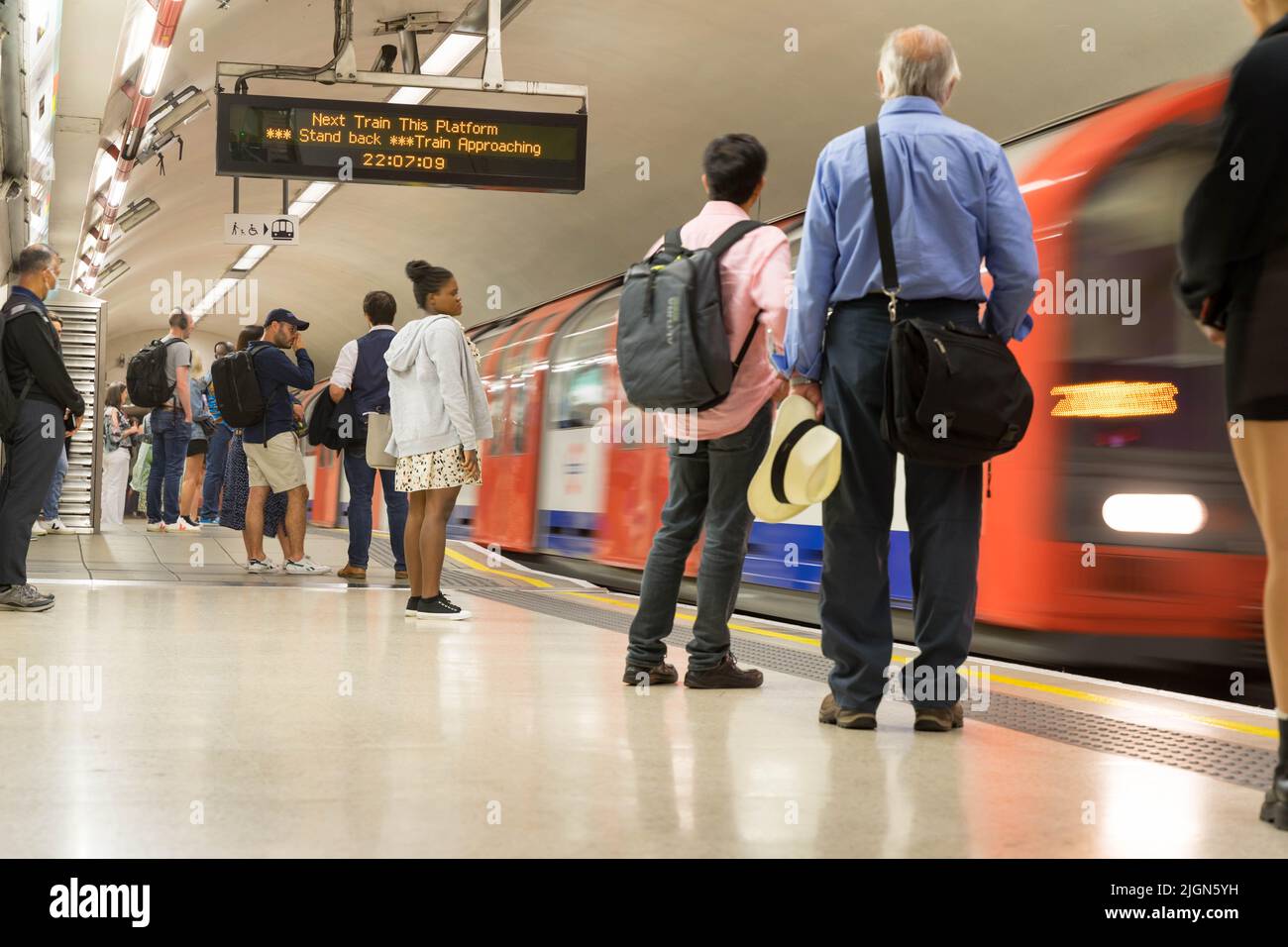 Los viajeros de la ciudad de Londres esperan en la plataforma en la estación bancaria como un tren subterráneo que se acerca a la plataforma Londres Inglaterra Reino Unido Foto de stock