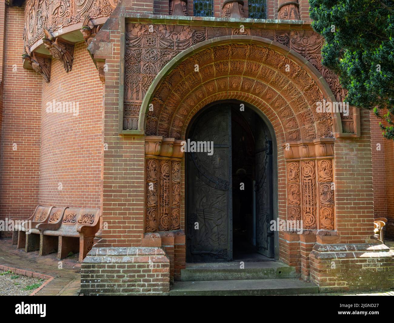 Puerta de metal ornamentada y terracota tallada rodean la entrada a la capilla Watts, Compton, Surrey, Reino Unido Foto de stock