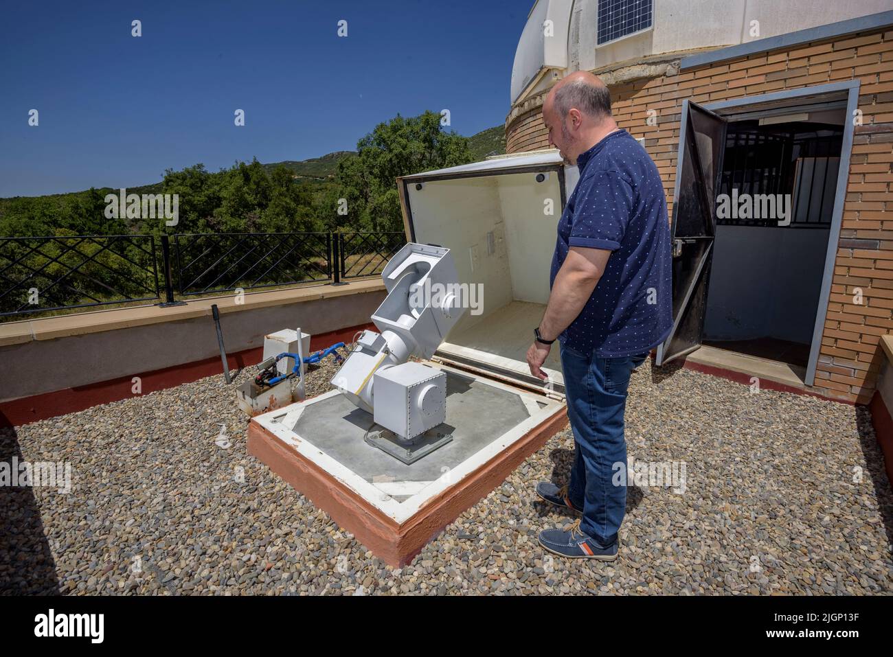 Salvador Ribas, director del Centro de Observación del Universo, maniobrando un telescopio en el Parque Astronómico del Montsec, en Àger (Lleida, Cataluña) Foto de stock