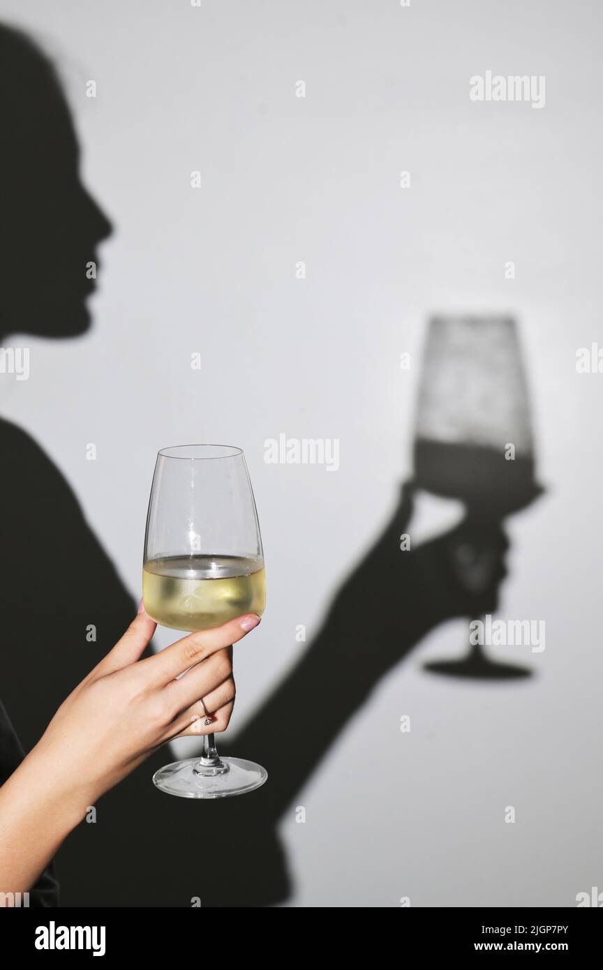 Abstract Woman shadow y copa de vino blanco Foto de stock