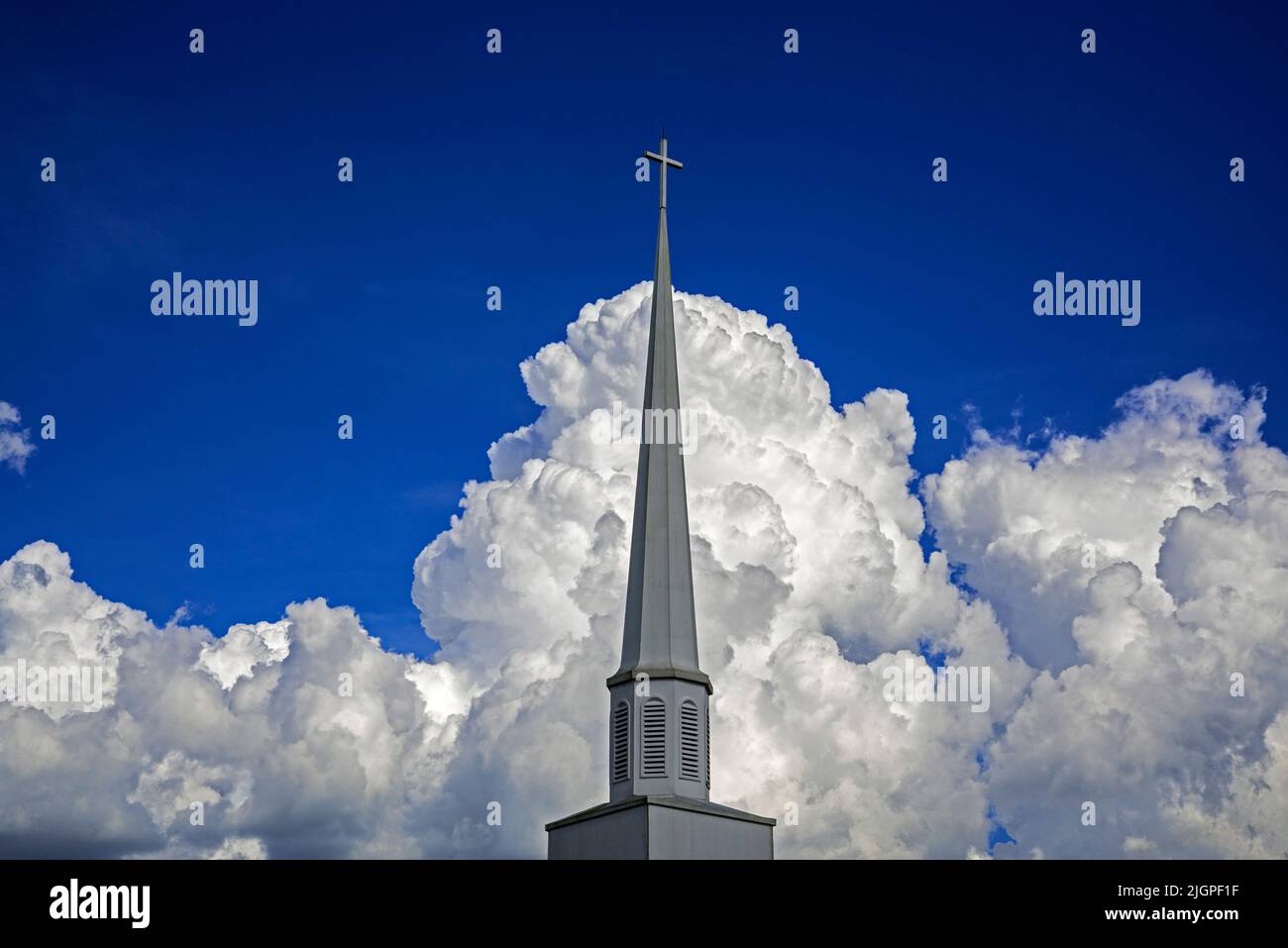 Hermosas nubes forman un telón de fondo dramático para un campanario de la iglesia en el norte de Florida Central. Foto de stock