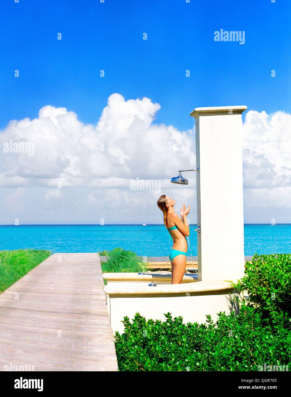 Mujer tomando una ducha al aire libre en el resort Regent Palms, Turks and Caicos Foto de stock