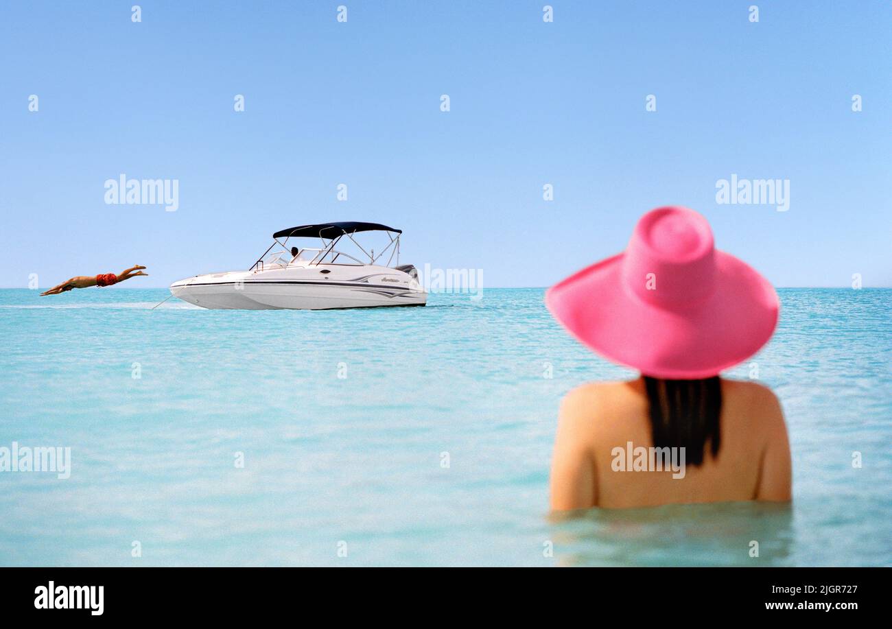 Mujer en el mar con barco en la distancia, Parrot Cay, Turcas y Caicos Foto de stock