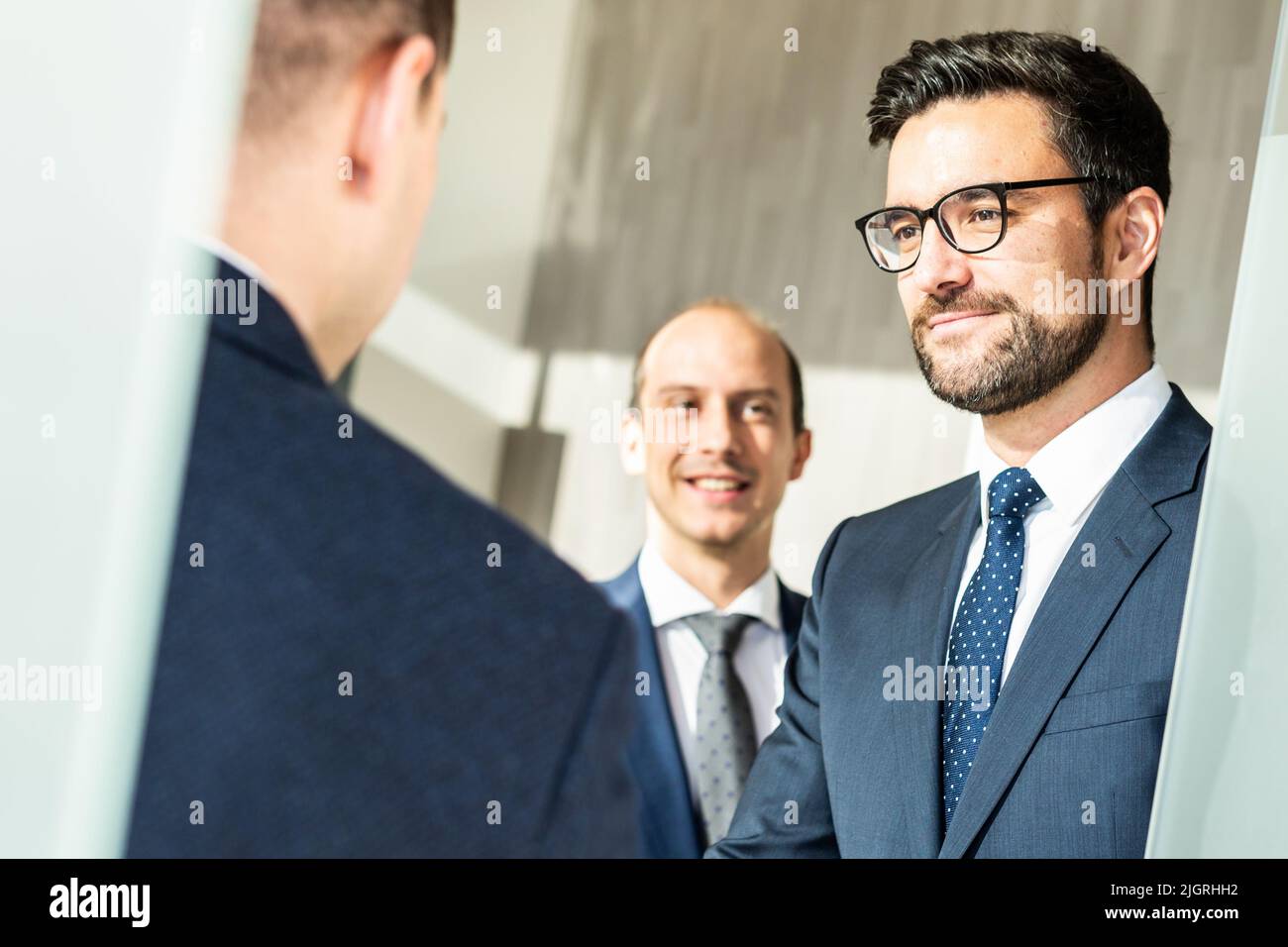 Un grupo de personas de negocios confiadas saludan con un apretón de manos en una reunión de negocios en una oficina moderna o cerrando el acuerdo de trato agitando las manos. Foto de stock