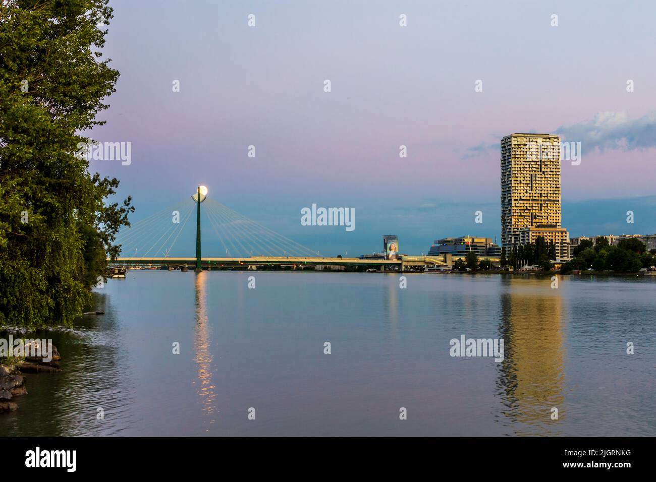 Wien, Viena: río Donau (Danubio), torre de altura Marina, metro en el puente del metro Donaustadtbrücke, luna llena, vista desde la isla Donauinsel en 02. Le Foto de stock