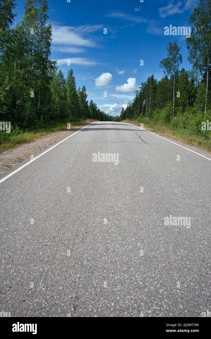 Carretera asfaltada vacía en paisaje rural, Finlandia Foto de stock