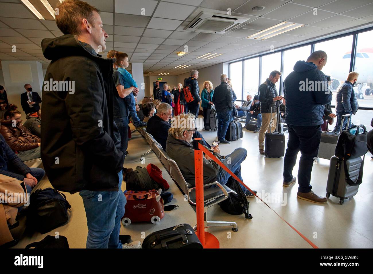 sección de embarque rápido de pasajeros de easyjet que esperan a la salida del avión en el aeropuerto internacional de belfast, reino unido Foto de stock