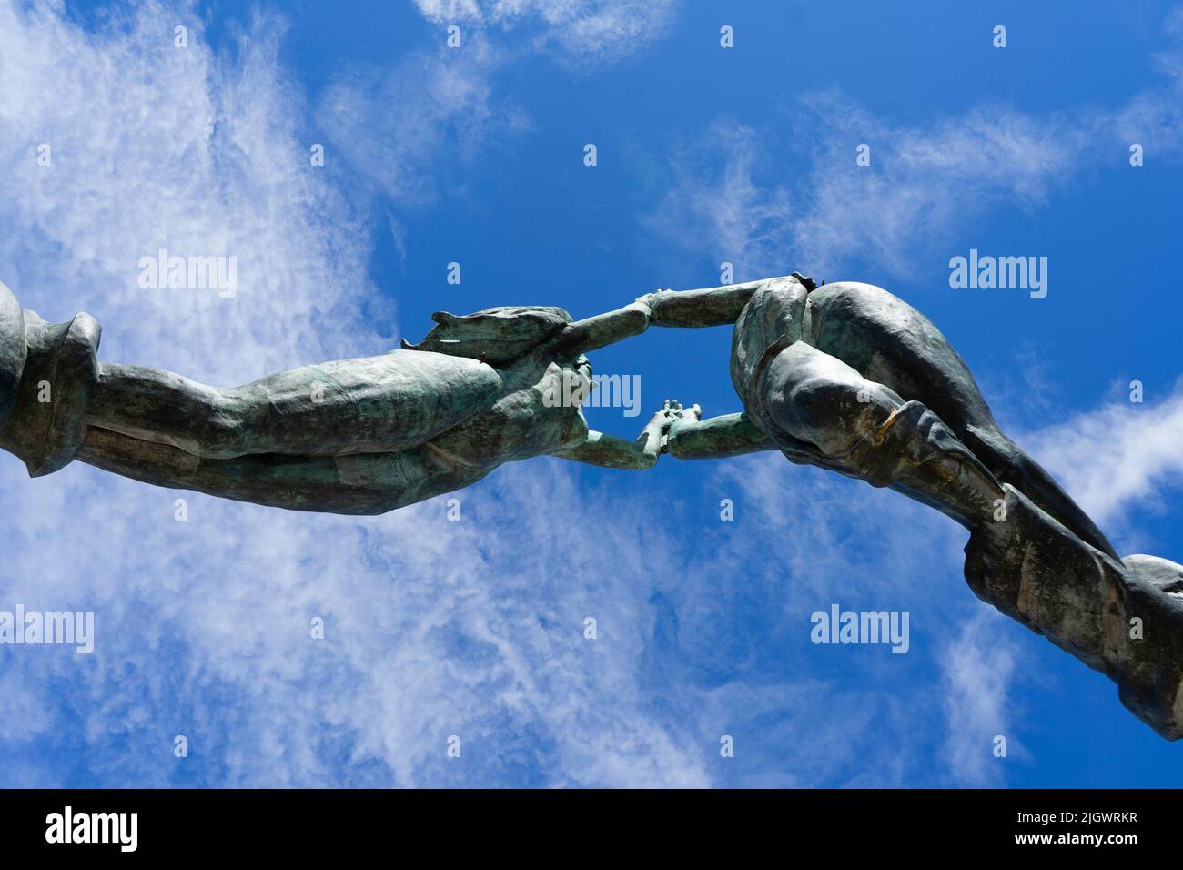 Estatua de bronce contra el cielo azul de los dos amantes en Playa del Carmen, México. Tomada desde abajo. Estatuas de mano Foto de stock