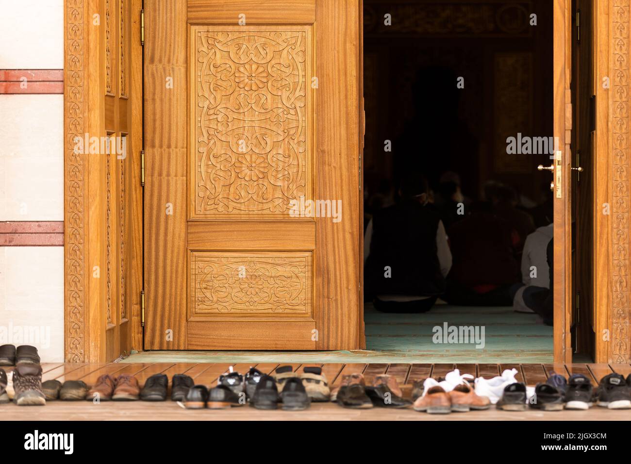Gente rezando en una mezquita. Zapatos delante de la mezquita Foto de stock