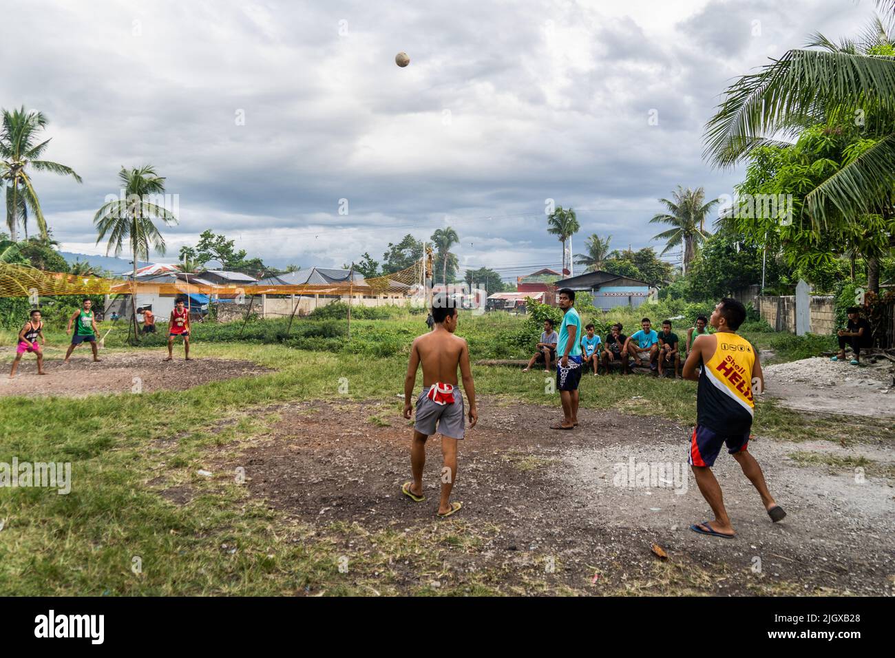 Moalboal, Filipinas. 13th de julio de 2022. Los lugareños juegan al voleibol por la tarde en un pueblo cerca de la playa. Vida diaria en el distrito de Moalboal, Cebu, Filipinas. La zona, antes conocida por su buceo y sus enormes nubes de sardinas, ha luchado para reactivar el turismo incluso después de levantar las restricciones a los viajes de los covid-19 debido a los daños críticos en la infraestructura causados por el tifón Rai, también conocido como Super tifón Odette, que ha dejado gran parte de la zona diezmada y luchando por reconstruir. Crédito: SOPA Images Limited/Alamy Live News Foto de stock