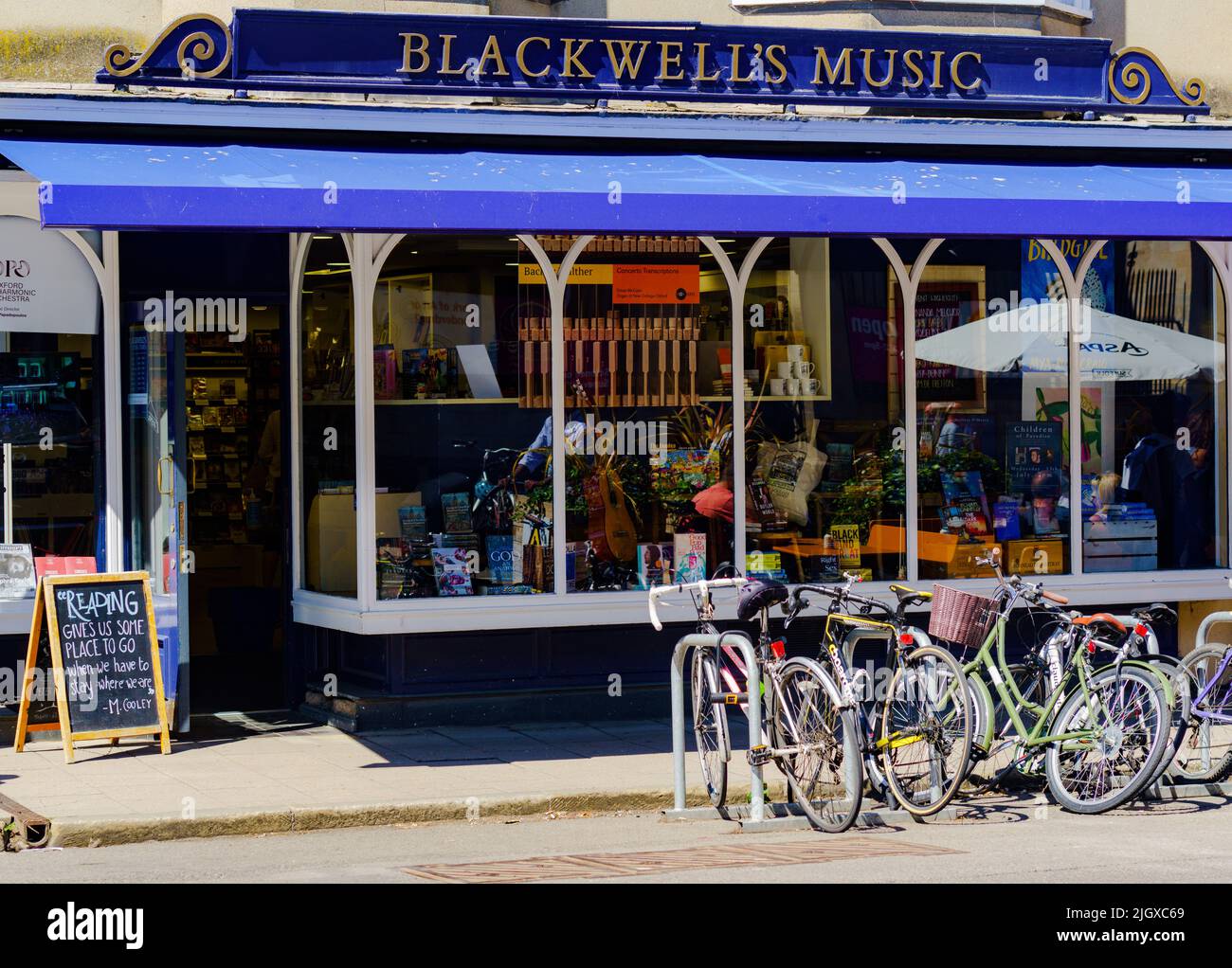 Tienda Blackwell's Music, Broad St, Oxford. Reflexiones en la ventana desde el área circundante. Estante para bicicletas en la parte delantera. Foto de stock