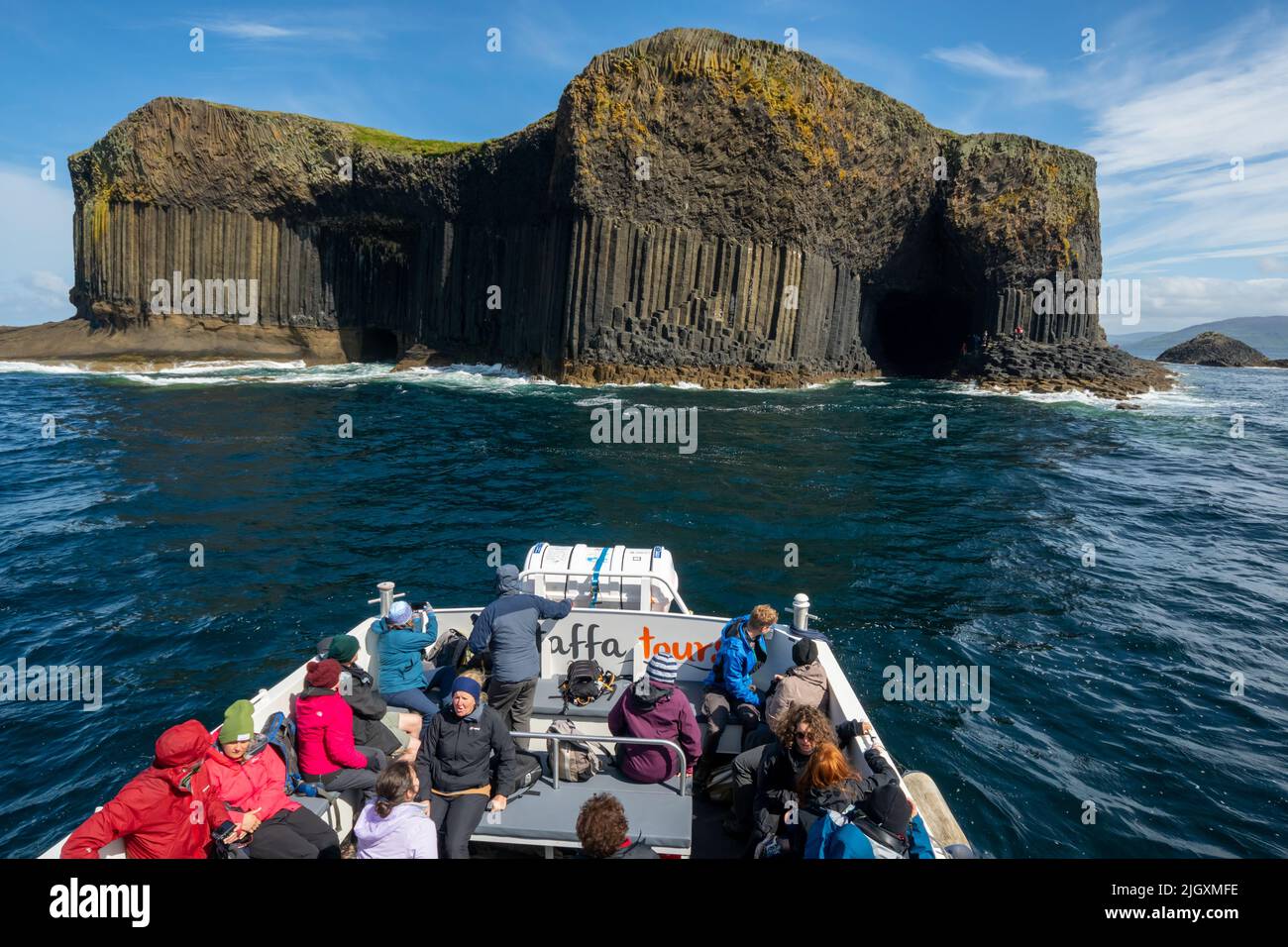 Isla de Staffa (Hébridas Interiores), con entradas a la cueva del barco (izquierda) y a la cueva de Fingal (derecha). Vista desde un barco turístico Foto de stock