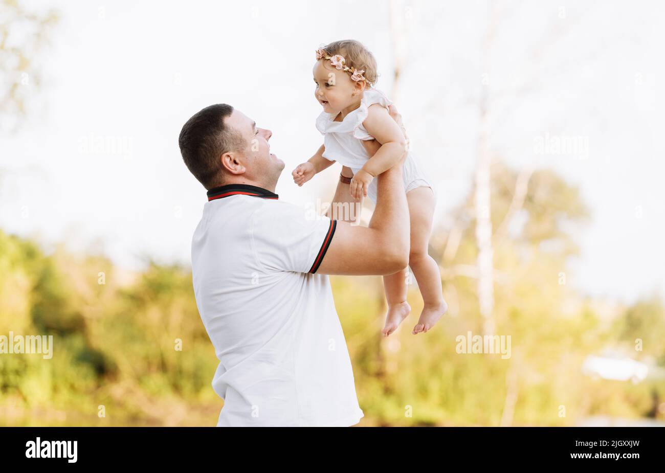 Día del Padre. Papá está abrazando a su hija bebé al aire libre y  divertirse en el estanque. Familia disfrutando de la vida juntos en la  naturaleza. Feliz día de la joven