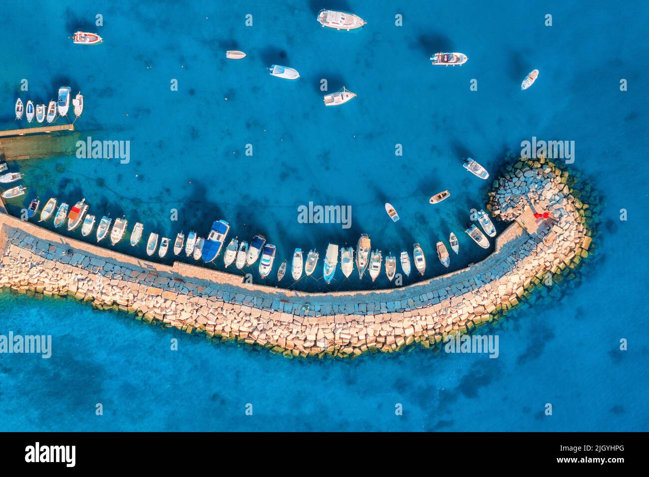 Vista aérea de barcos y yates en muelle, rompeolas y mar azul Foto de stock