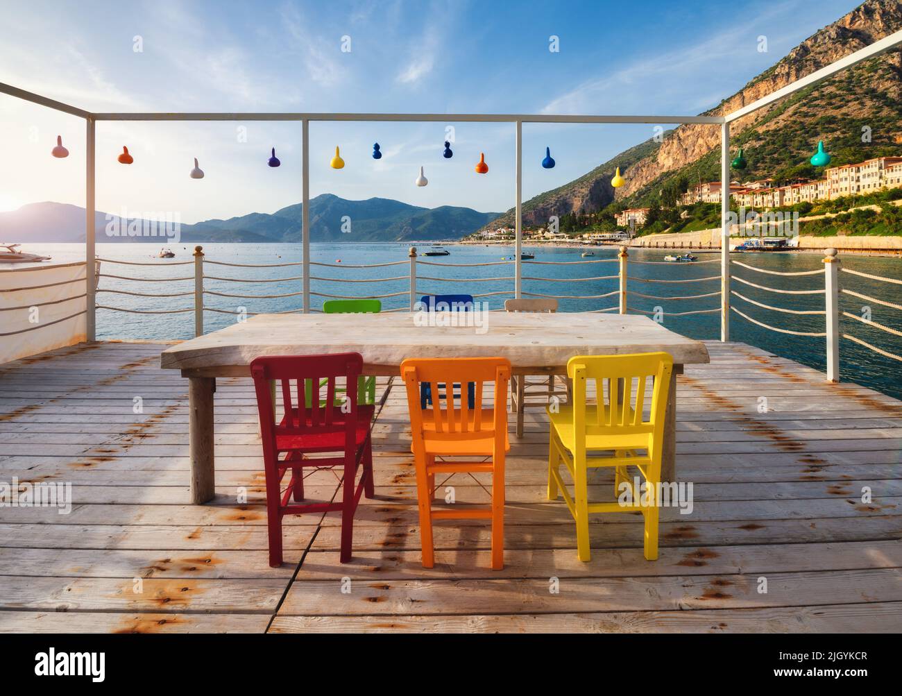 Hermosa cafetería en el muelle de madera en el mar al atardecer en verano. Foto de stock