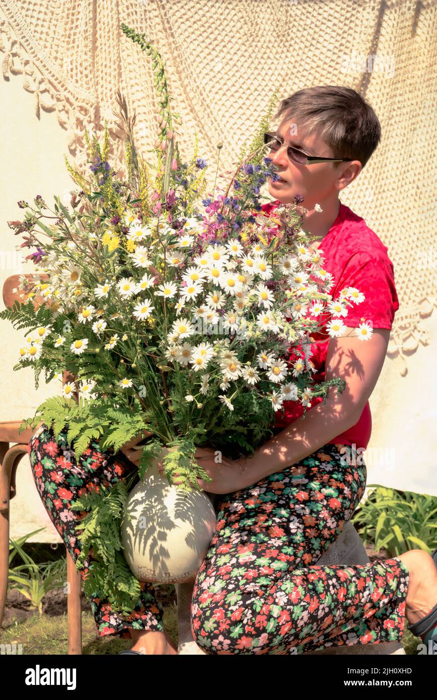 floristería en el trabajo - retrato de una mujer con un ramo de flores silvestres Foto de stock