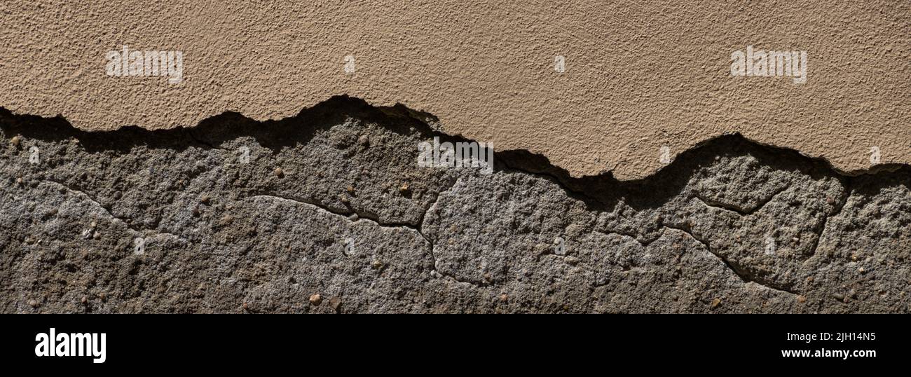 Pared de arenisca vieja con pedazos gruesos de yeso roto Foto de stock