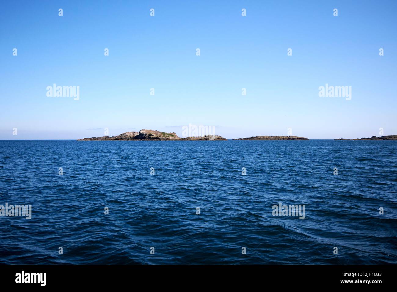 en el mar frente a la costa norte de las islas skerries de irlanda del norte en una mañana de verano Foto de stock