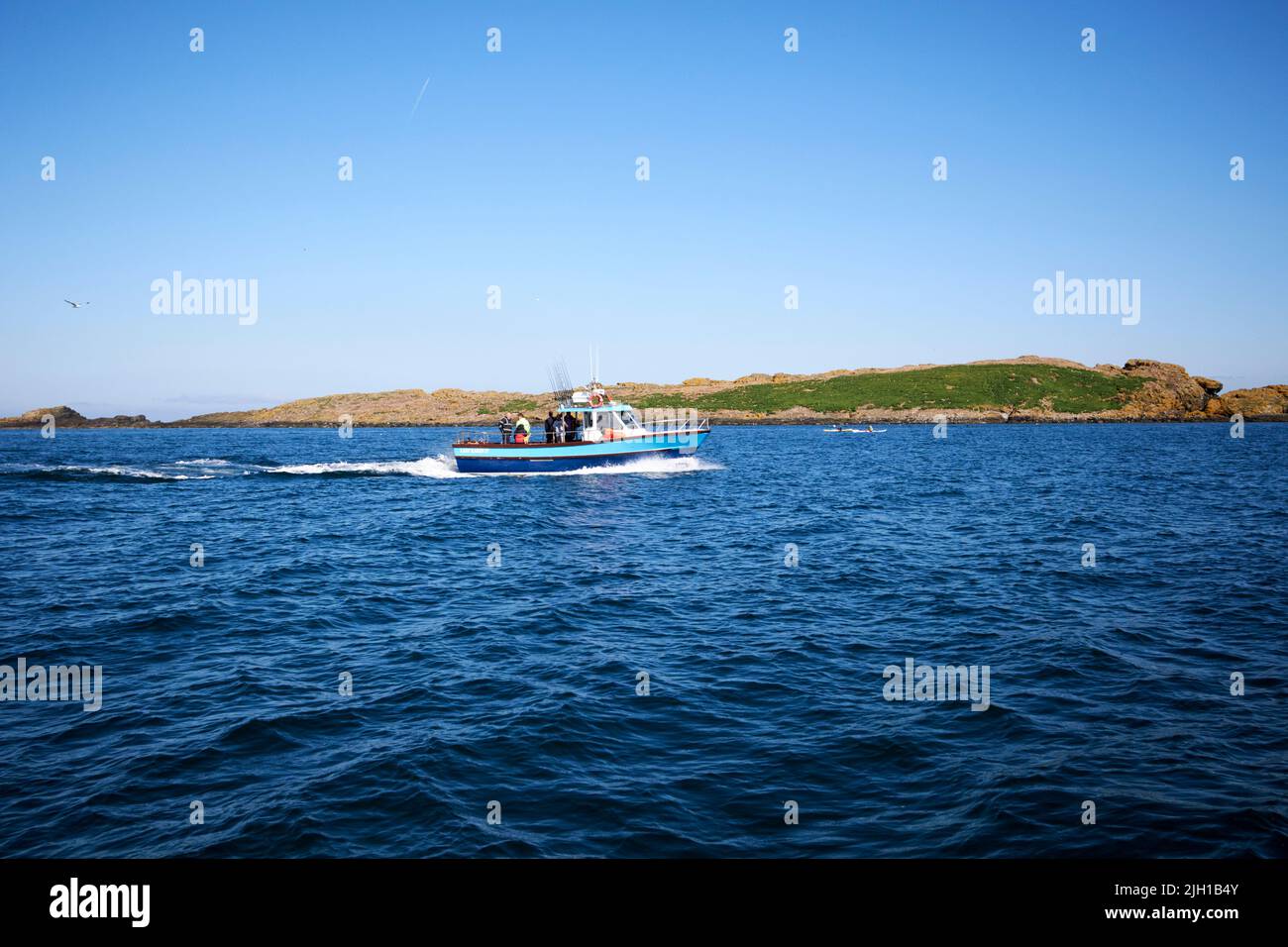 pequeño barco de pesca en el mar frente a las praderas cerca de portrush, en la costa norte de irlanda del norte Foto de stock