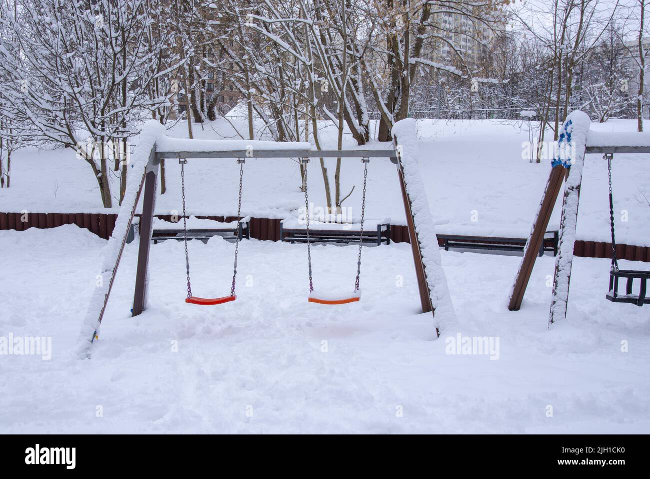 Un parque infantil vacío en la nieve. Foto de stock