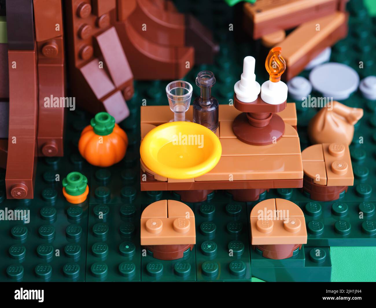 Tambov, Federación Rusa - 22 de junio de 2022 Una mesa de picnic de Lego con un plato, un vaso, una botella y una vela bajo un árbol Foto de stock