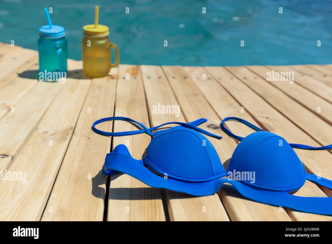 Bañador y dos cócteles de amarillo y azul junto a la piscina. Fiesta en la piscina al aire libre Foto de stock