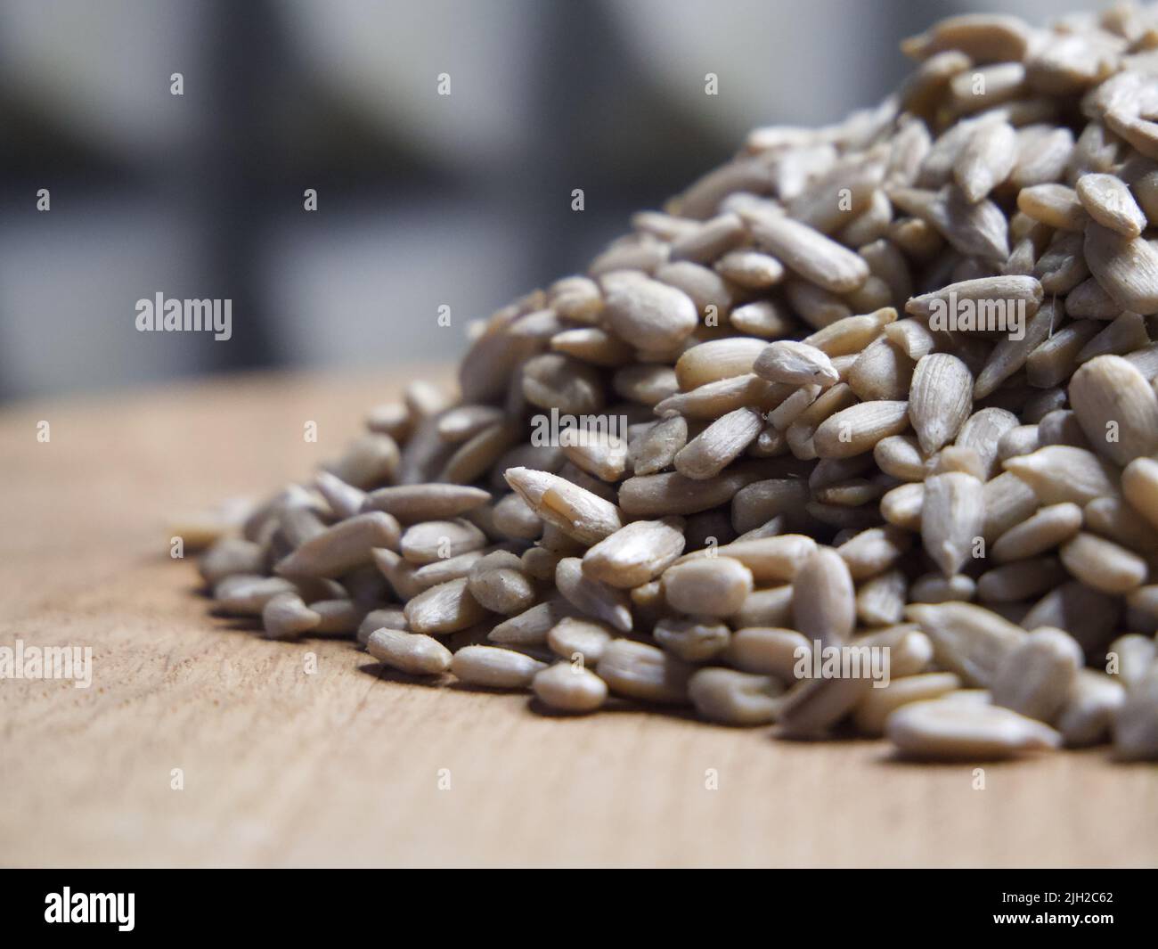 Un montón de semillas de girasol peladas sobre una superficie de madera, macro tiro. Semillas sin cáscara. Foto de stock