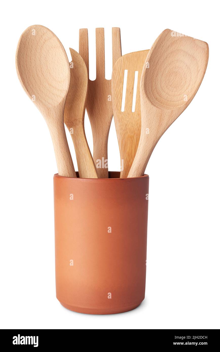 Juego de utensilios de cocina de madera, cuchara, tenedor y espátula, en un recipiente de terracota, aislado sobre fondo blanco Foto de stock