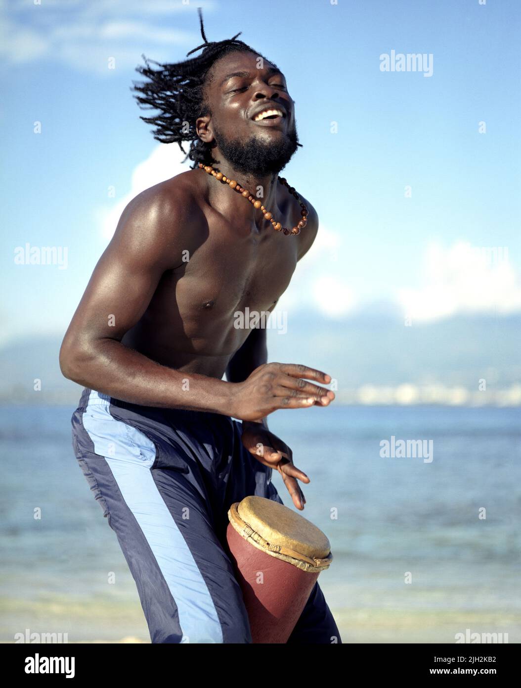 El artista de reggae 'Coolant' toca un tambor/bongo en Lime Cay Island. A 15 minutos en barco de Kingston, Jamaica Foto de stock