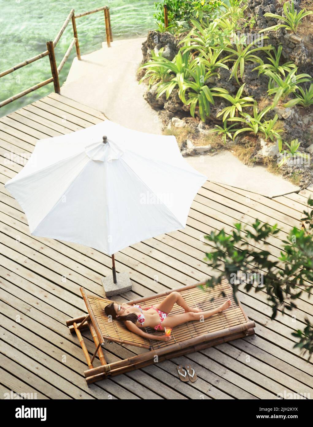 Mujer relajándose en la terraza en el resort tropical Foto de stock
