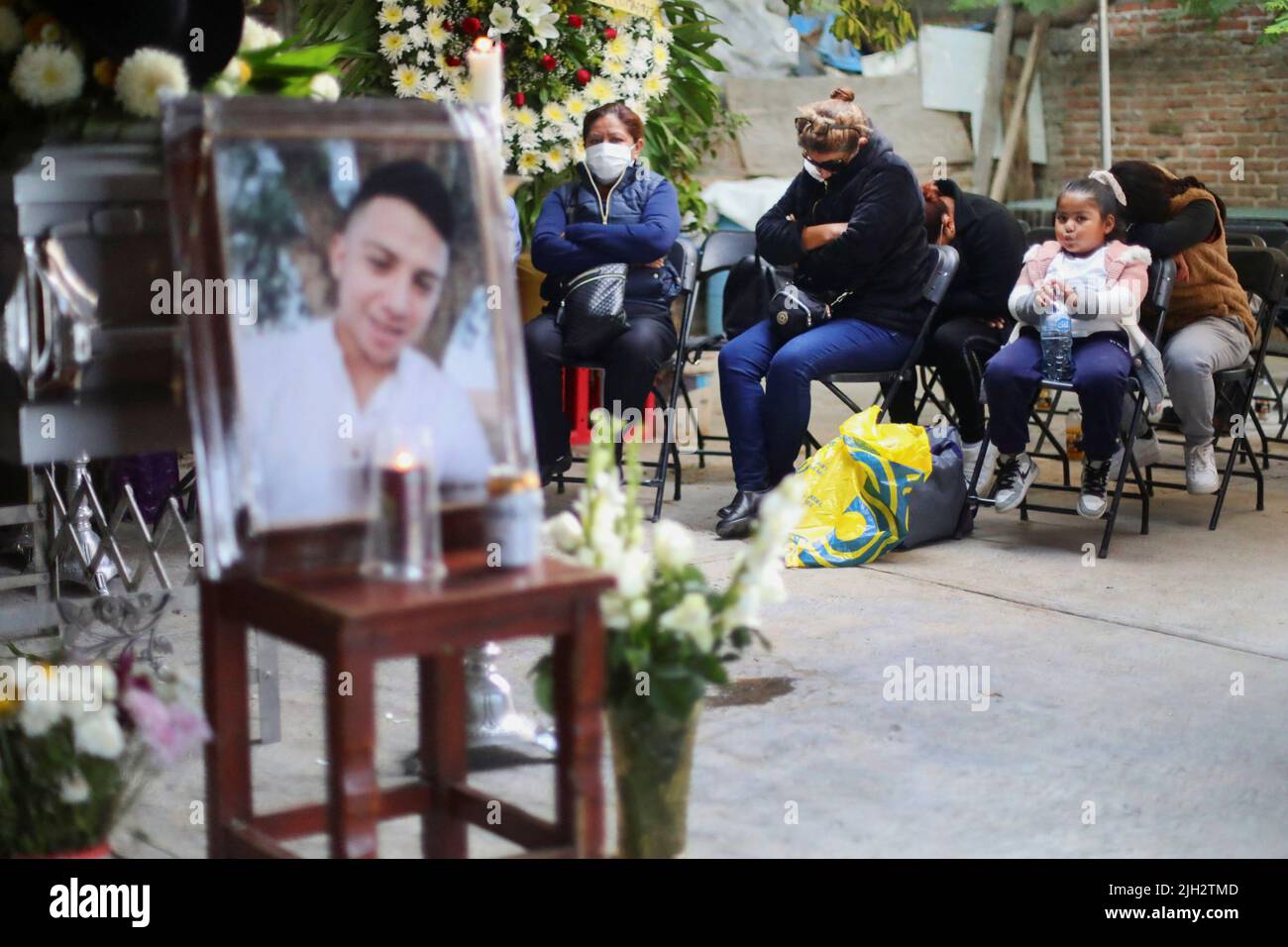 La madre del difunto Efrain Ferrel, de 22 años, y otros parientes se sientan junto a su ataúd durante su estela, después de ser repatriado de San Antonio, Texas, EE.UU., en la casa de su familia en Celaya, en el estado de Guanajuato, México, el 14 de julio de 2022. REUTERS/Edgard Garrido Foto de stock