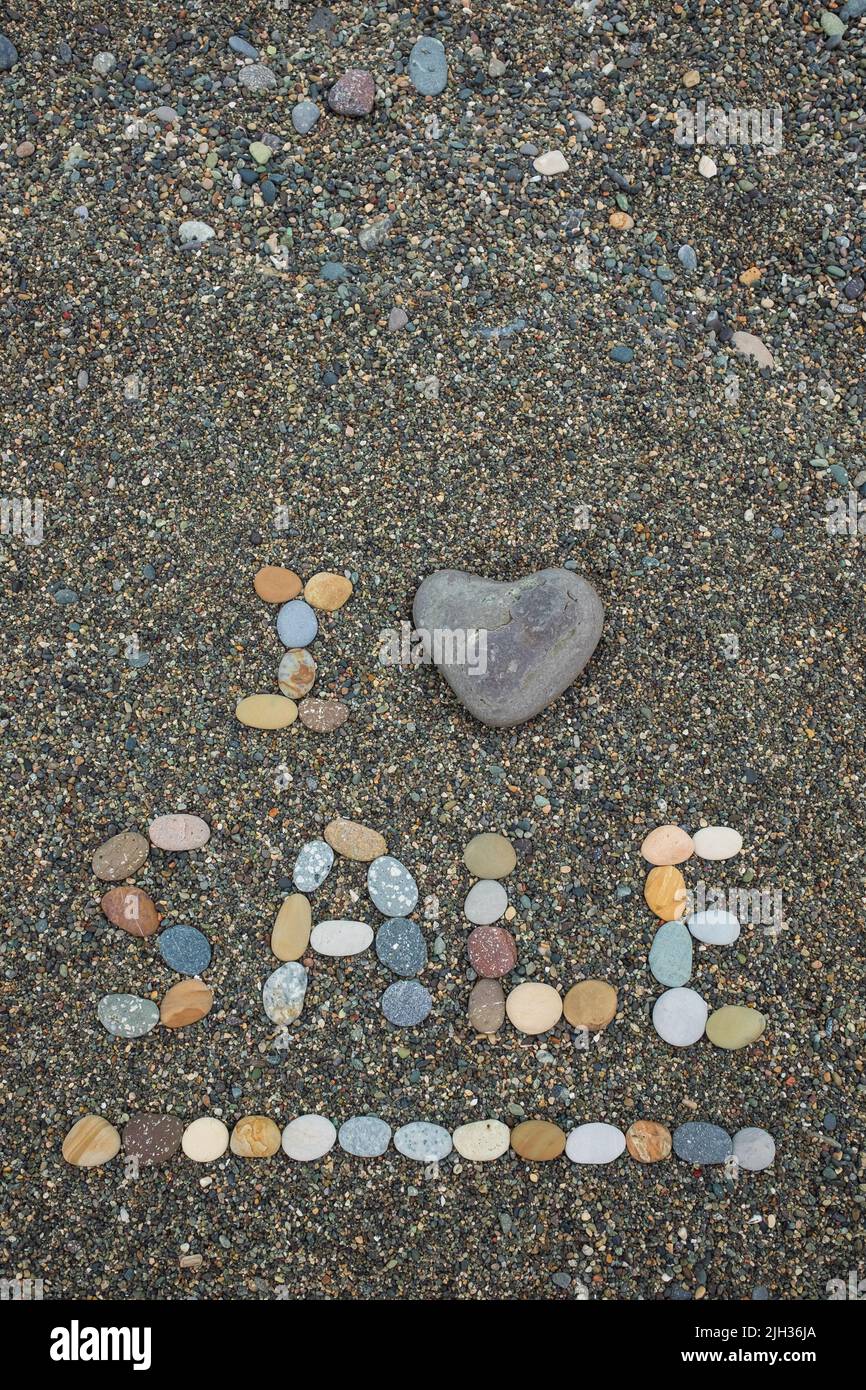 Me encanta la venta hecha de piedras en la playa de arena. Concepto de venta caliente Foto de stock