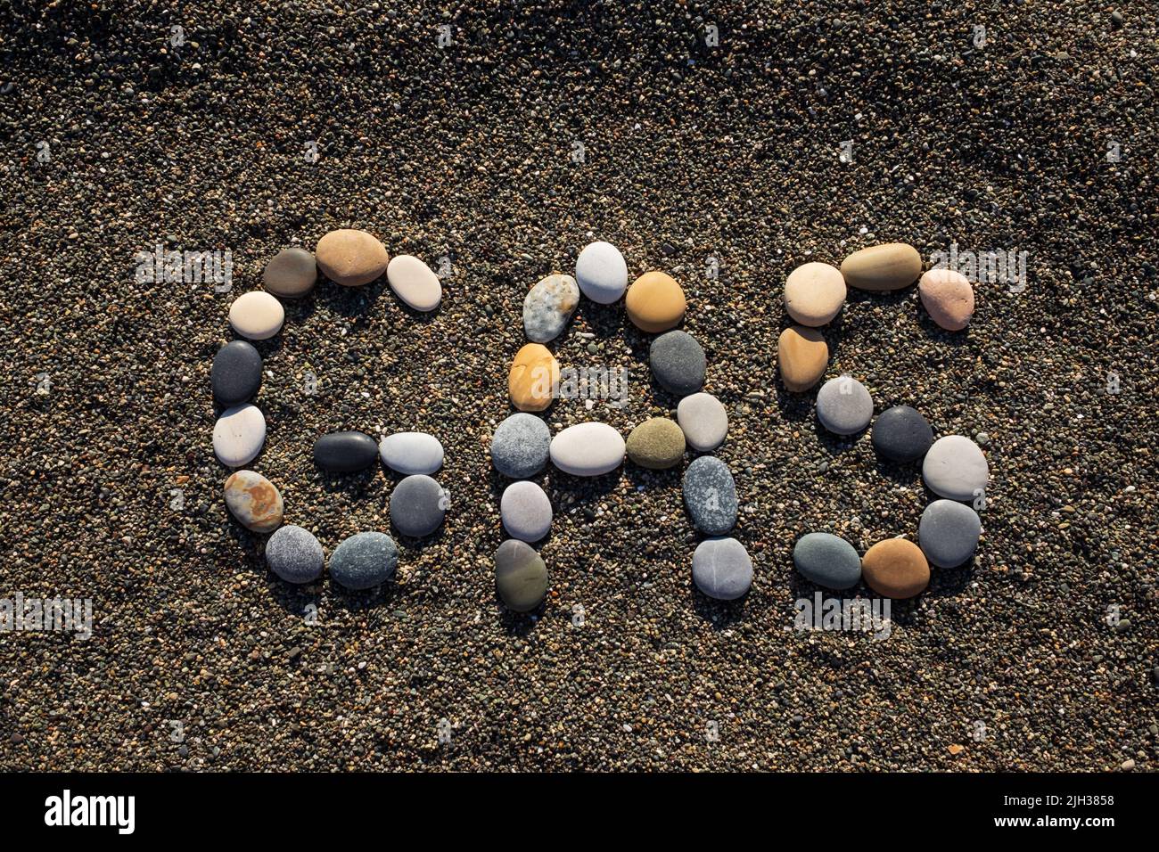 Gas palabra piedra en la playa de arena. Concepto de energía y combustible Foto de stock