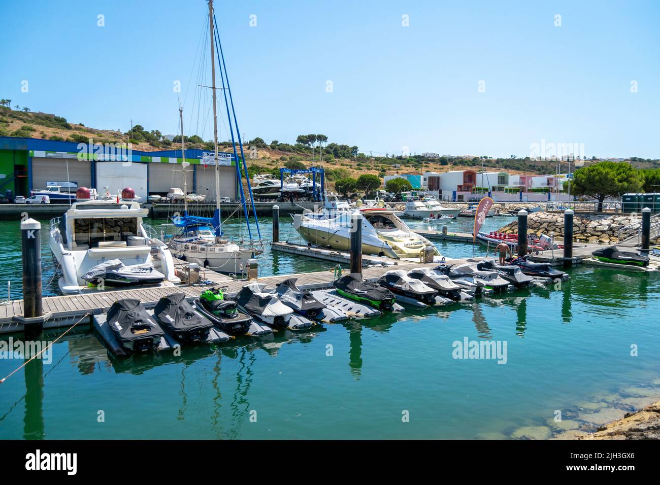 Marina de Albufeira, Algarve, Portugal. Chorros de agua estacionados cerca de los barcos. Horario de verano, Europa y destinos de viaje. Foto de stock
