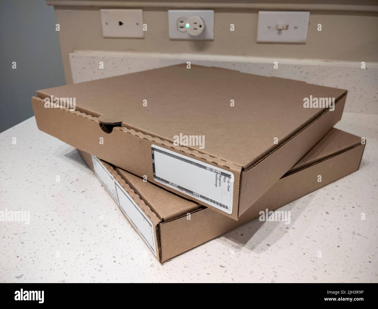 Vista de cerca de dos cajas de cartón para pizza en una encimera de cocina Foto de stock