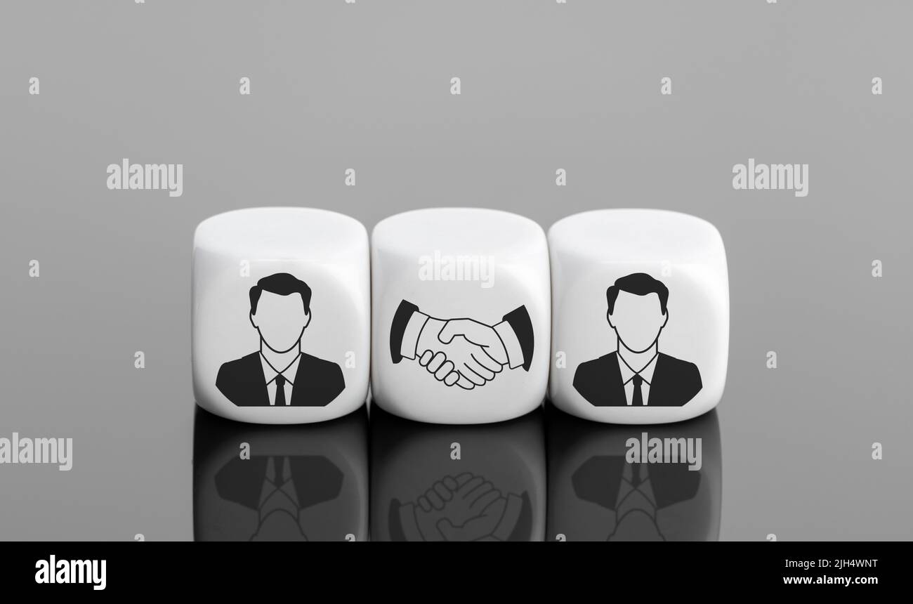 Acuerdo, asociación o concepto de acuerdo. Icono del hombre de negocios y icono del apretón de manos sobre bloques blancos. Espacio de copia Foto de stock