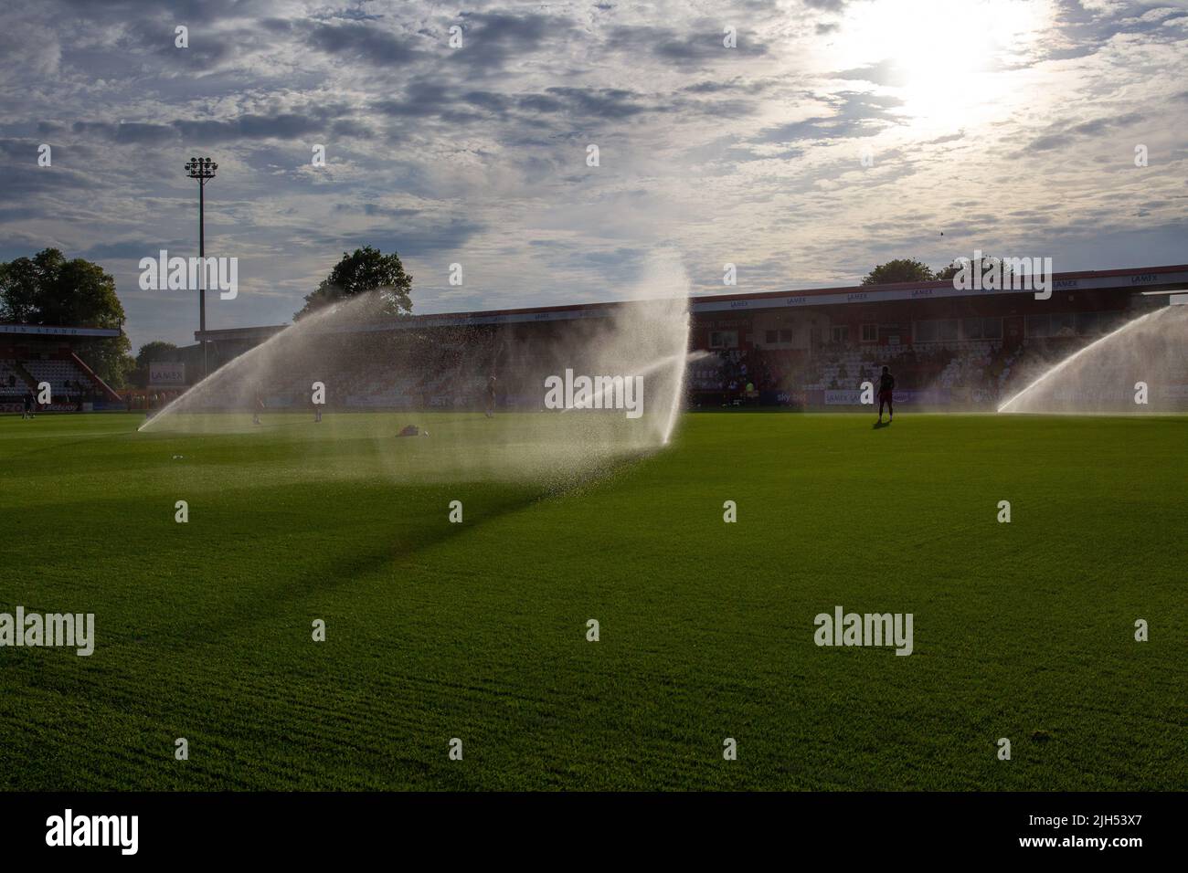 Sistema de rociadores de agua en funcionamiento en el estadio de fútbol antes del partido. Foto de stock