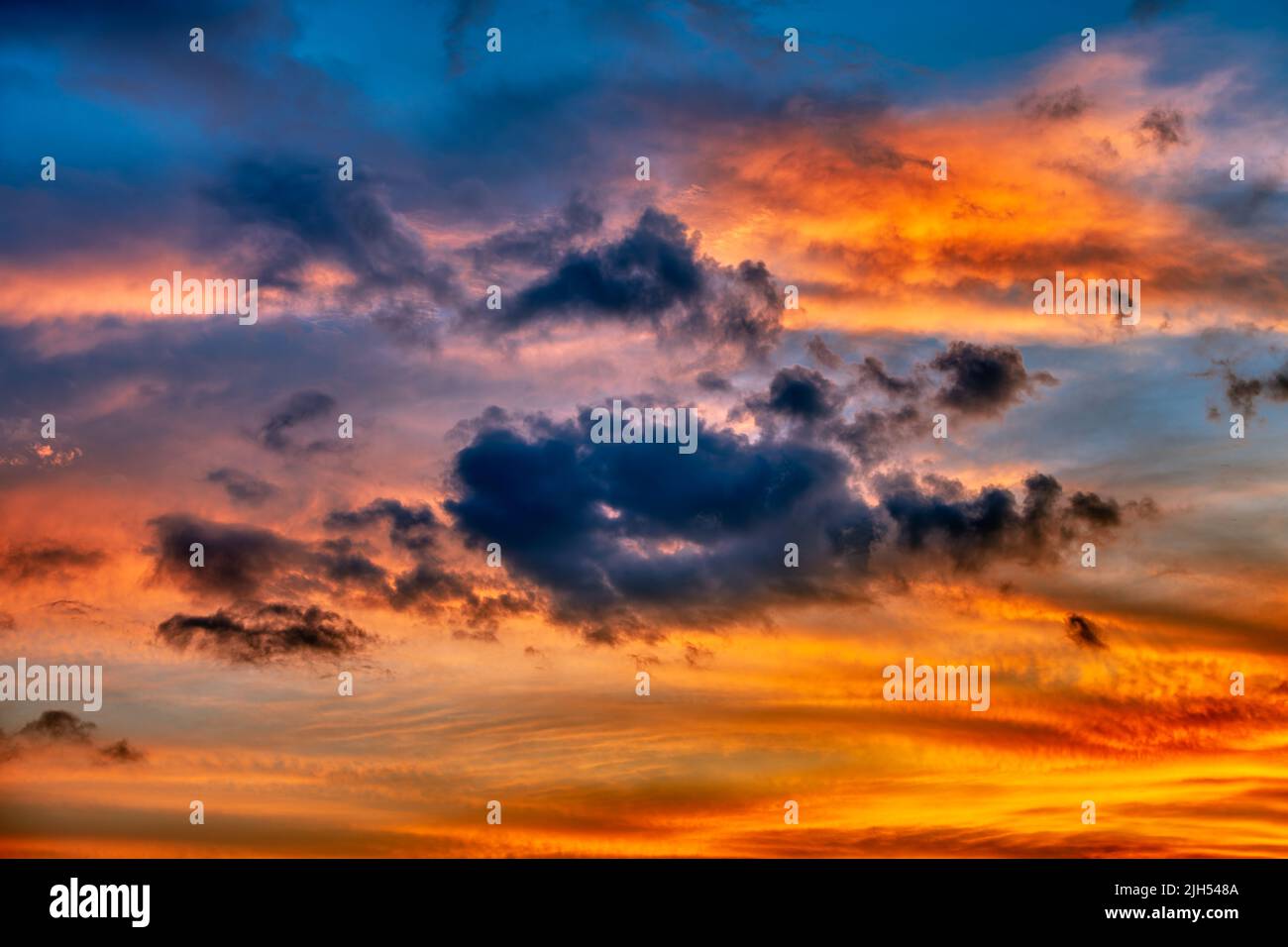 Un colorido y detallado Cloudscape llena el cielo al atardecer Foto de stock