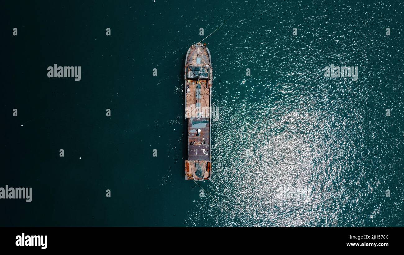 Barco pescador desde arriba en aguas turquesa Foto de stock