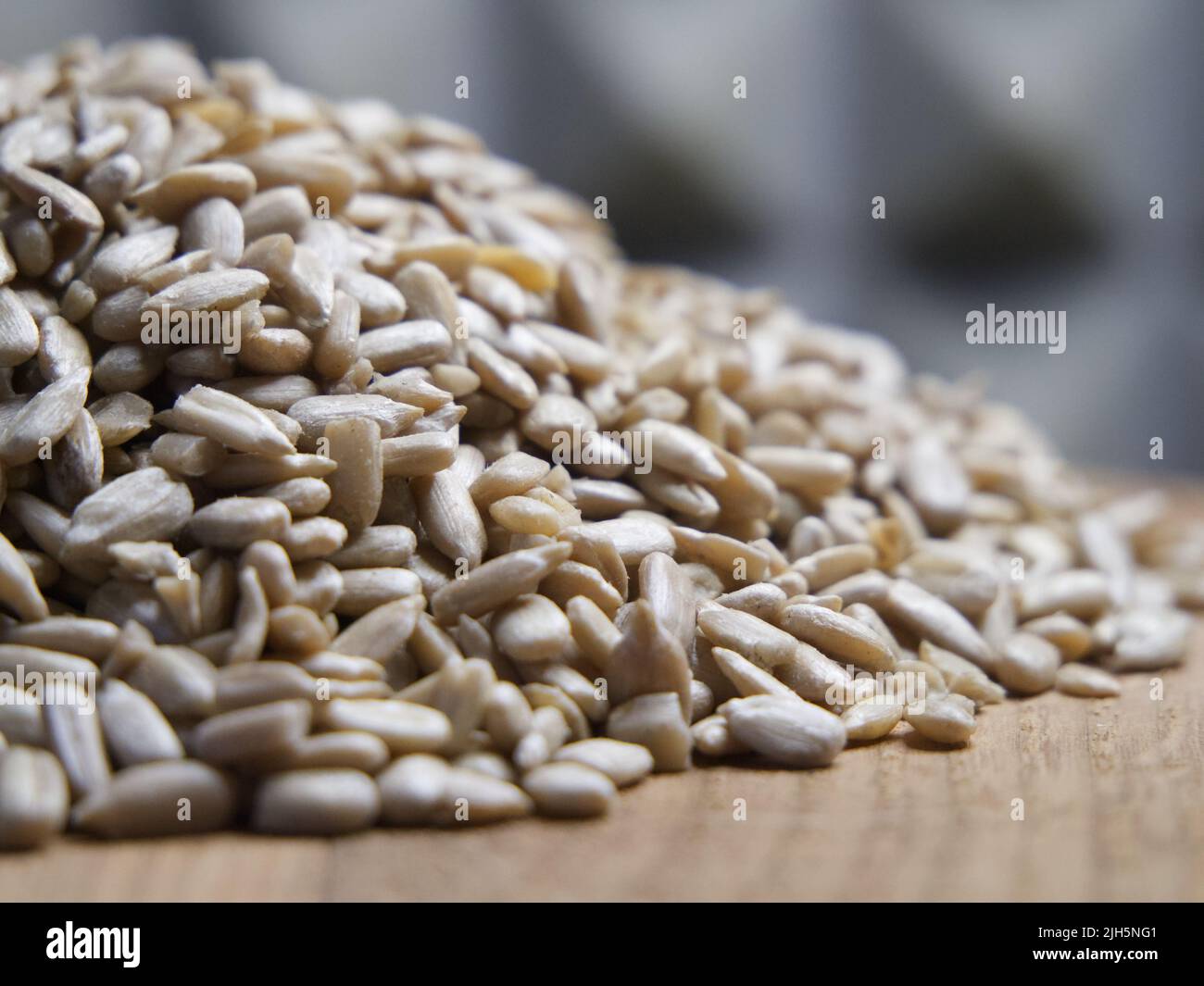 Un montón de semillas de girasol peladas sobre una superficie de madera, primer plano. Semillas sin cáscara. Foto de stock