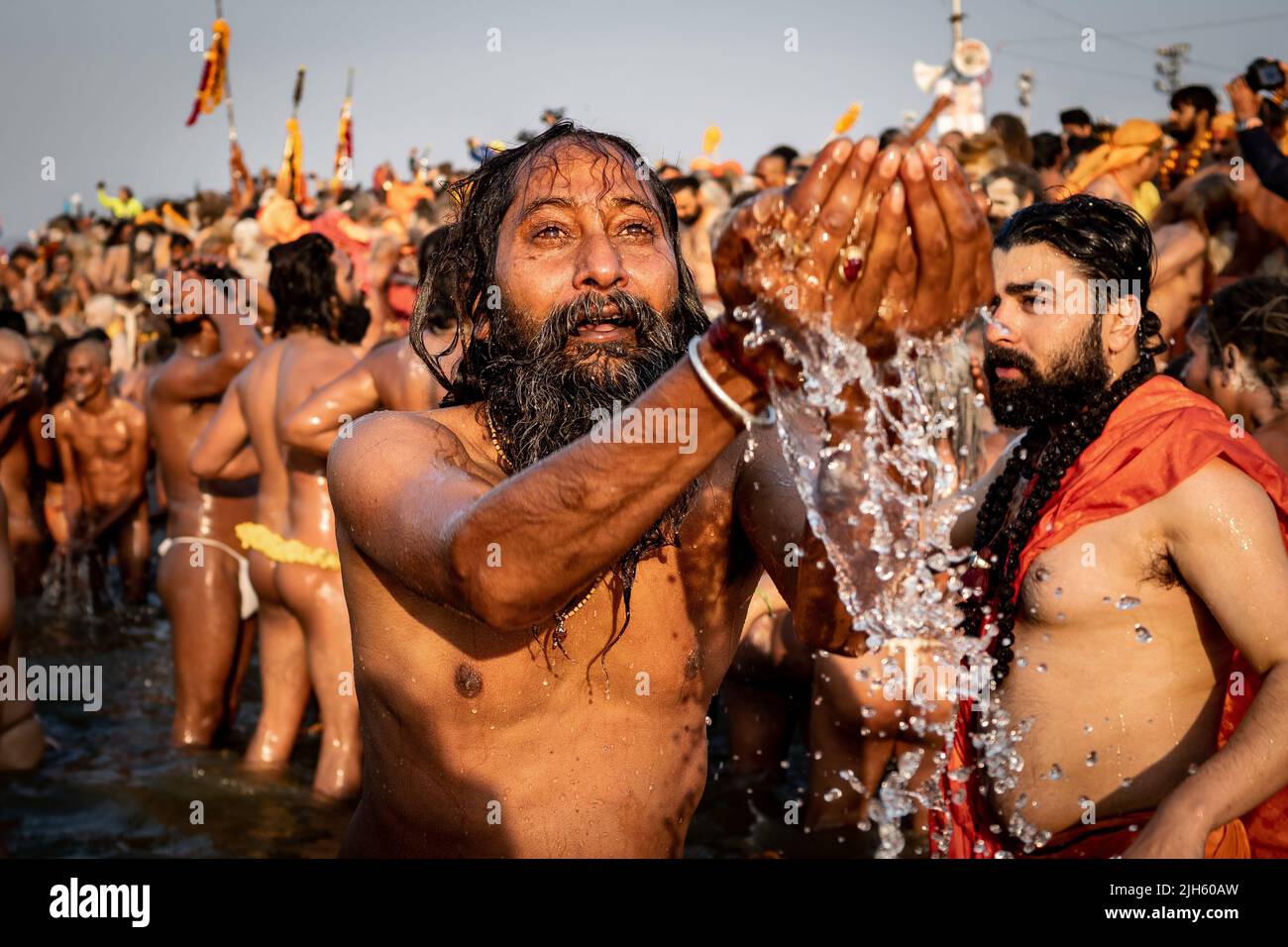 Un adorador hindú rezando y bañándose en el sagrado río Ganges con miles de otros devotos en el Festival Kumbh Mela en Allahabad, India. Foto de stock