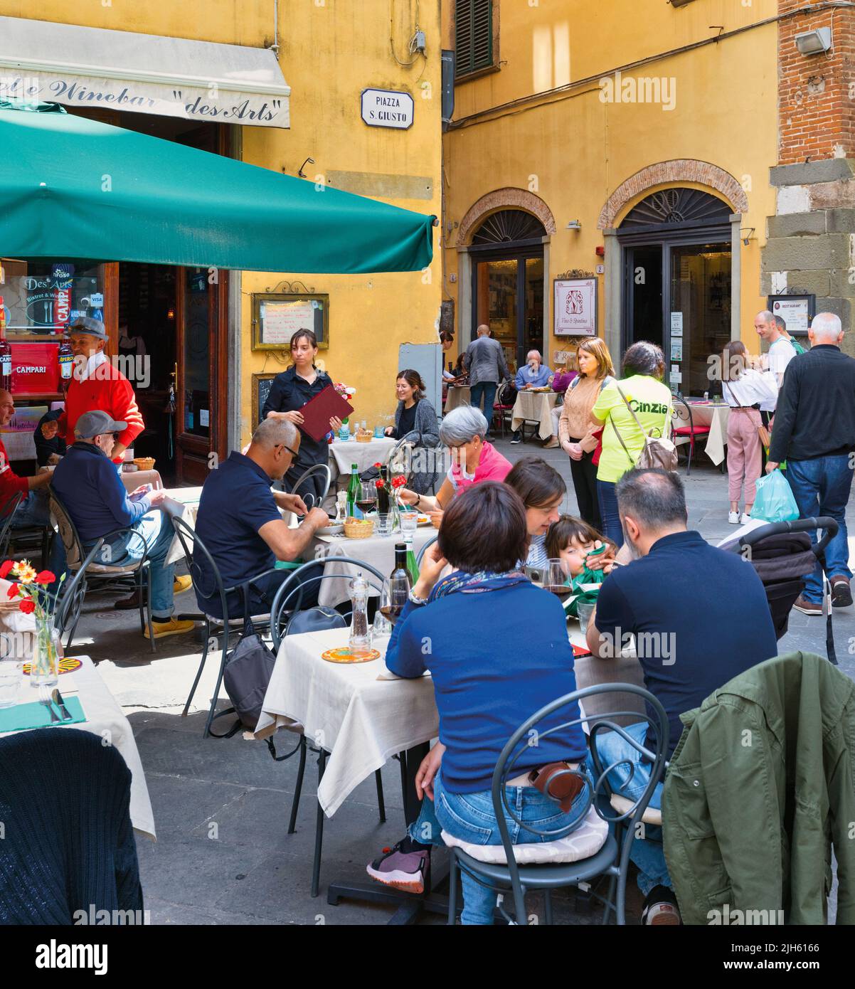 Los comensales disfrutan de la comida en la terraza de un restaurante en Piazza San Giusto. Lucca, provincia de Lucca, Toscana, Italia. Foto de stock