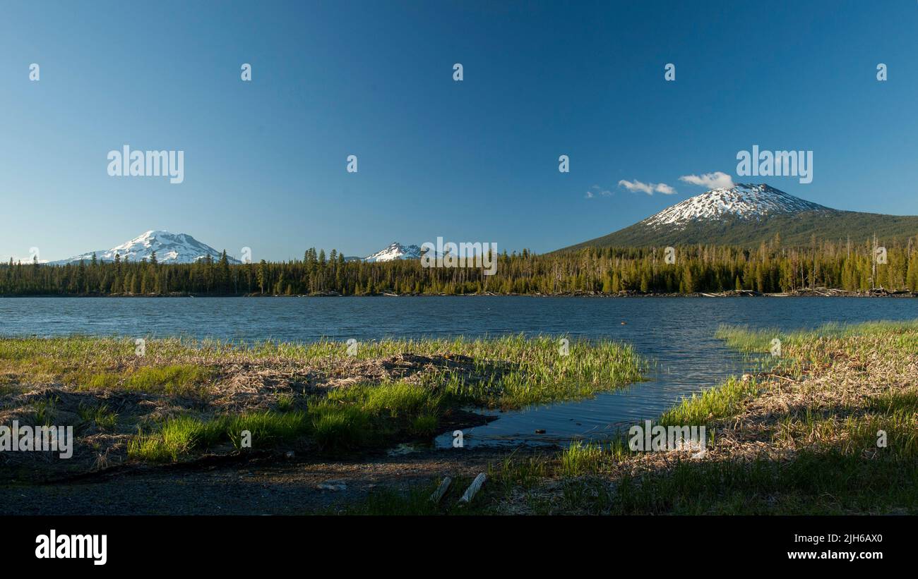 De izquierda a derecha: Hermana del Sur, Parte superior rota y Mt. Bachelor como visto desde Lava Lake en la ruta escénica de Oregon Cascade Lakes. Foto de stock